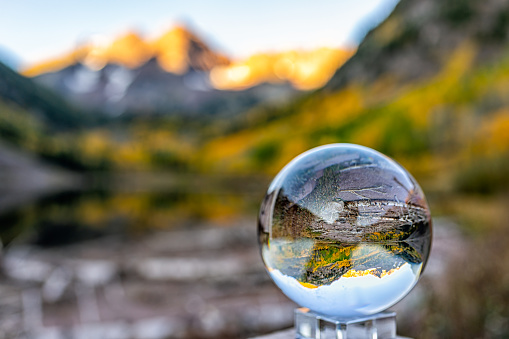 Maroon Bells lake at sunrise with crystal ball glass reflection in Aspen, Colorado with rocky mountain peak and snow in October autumn fall leaf color season