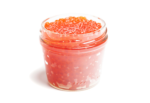 Glass jar with delicious red caviar isolated on white background