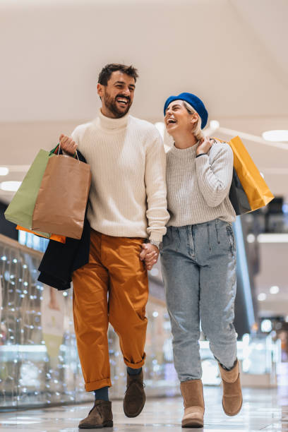 istock Happy couple having a laugh while doing Christmas shopping 1446294634