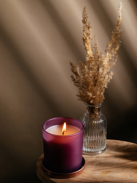 istock a burning candle on a round table with dried flowers 1446298176