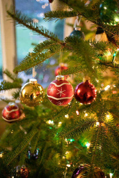 istock Vertical image of Christmas ornaments hanging on Christmas tree. 1446298345