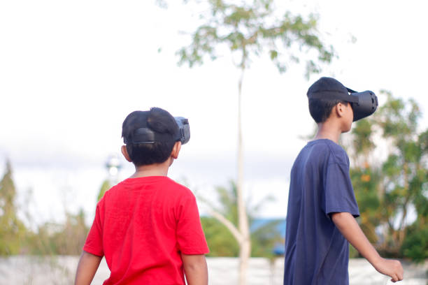 istock child with brother playing Virtual reality outdoor 1446300007