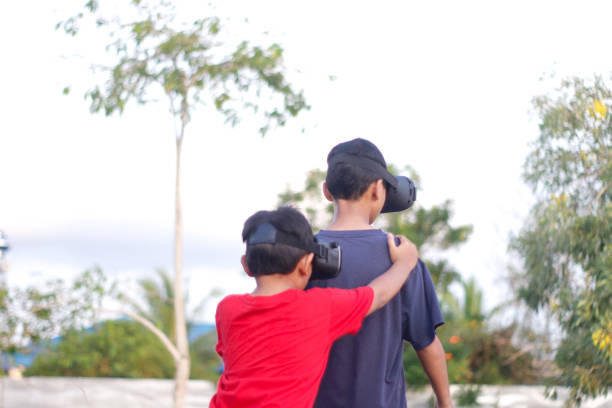 istock child with brother playing Virtual reality outdoor 1446300735