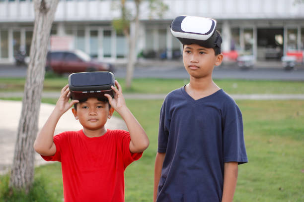istock child with brother playing Virtual reality outdoor 1446305284