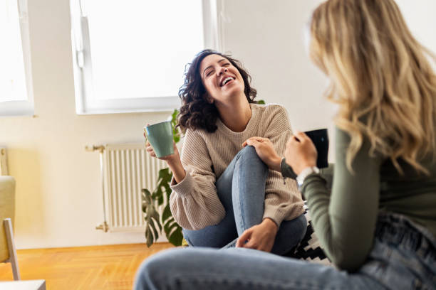 istock Smiling female friends talking drinking coffee 1446305938