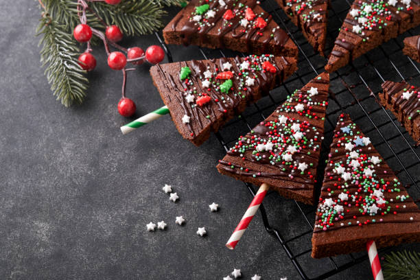 istock Chocolate brownies Christmas tree with chocolate icing and festive sprinkles on stone table. Christmas food ideas sweet homemade Christmas holidays pastry concept. Holiday cooking concept. Top view. 1446307483