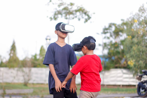 istock child with brother playing Virtual reality outdoor 1446308381
