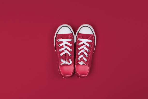 red sneakers top view close up on colorful background. color of the year 2023, viva magenta. - viva magenta 個照片及圖片檔