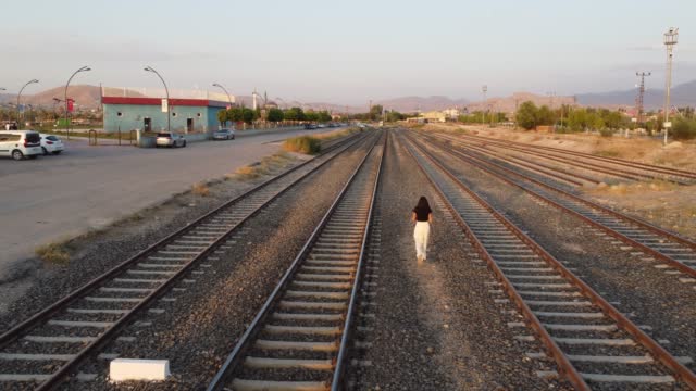 Woman walking on the train track.