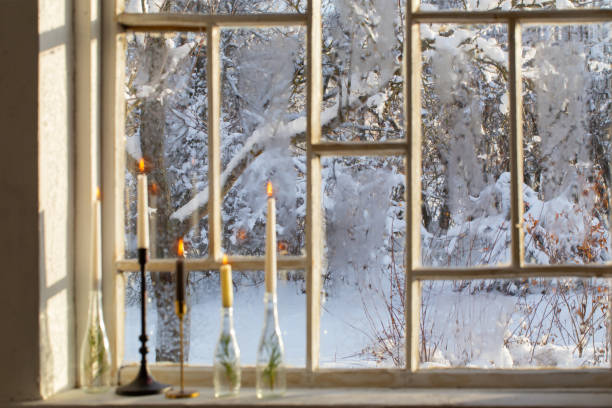 istock old window with winter landscape and burning candles on windowsill 1446313892