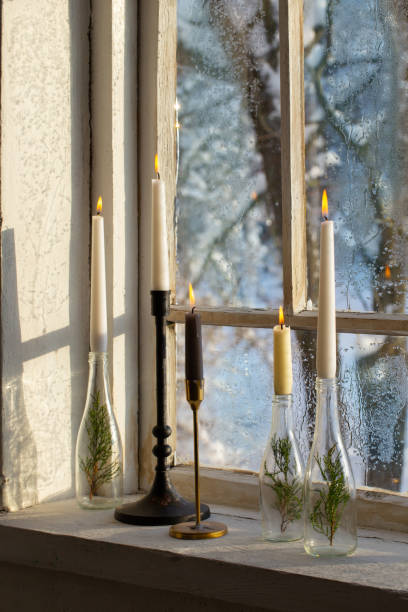 istock old window with winter landscape and burning candles on windowsill 1446313894