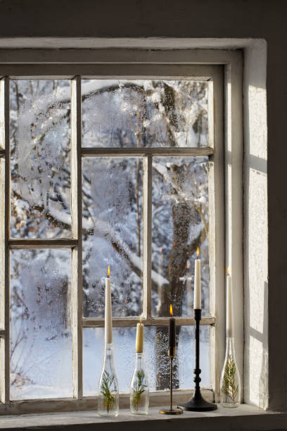 istock old window with winter landscape and burning candles on windowsill 1446313895