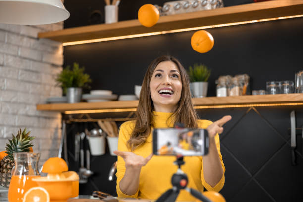 istock Beautiful woman making orange juice at home in kitchen 1446314116