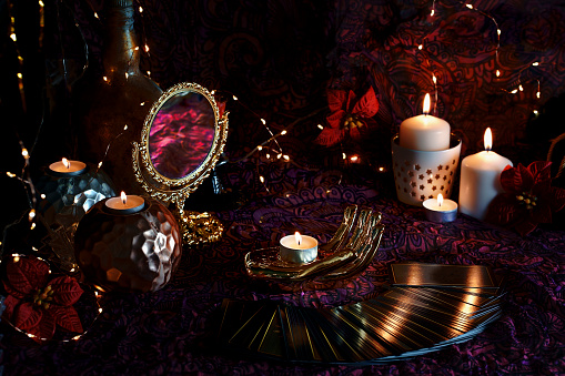 Blurred Tarot cards on table near burning candles. Tarot reader or Fortune teller reading on Christmas decoration