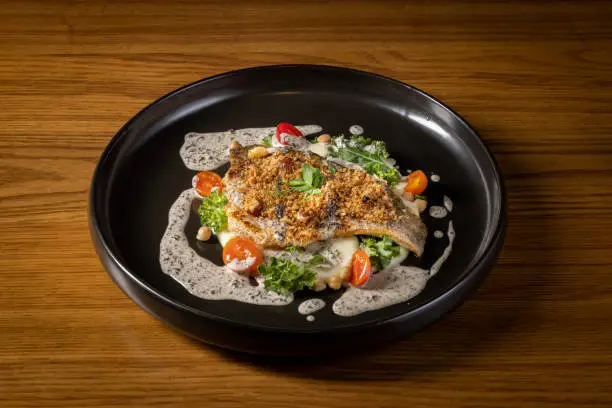 Pan Seared Barramundi served in dish isolated on table top view of thai food