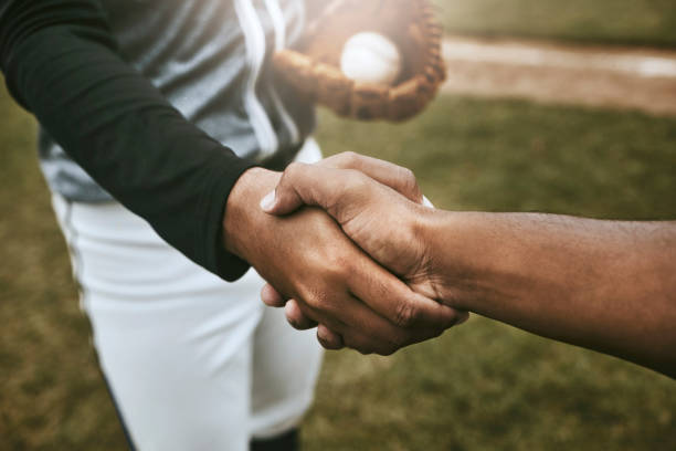 les joueurs de baseball se serrent la main avant le match sur le terrain de baseball pour avoir de la chance, de l’accord et du soutien. le sport, le fitness et les athlètes se serrent la main pour montrer l’unité, les meilleurs vœux et l’espoir d - baseball diamond flash photos et images de collection