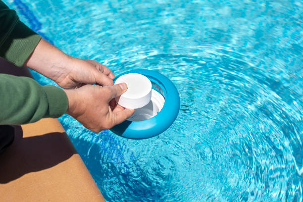 istock Operator introducing a white chlorine tablet into a floating dispenser in the pool at home in summer for disinfection and maintaining the proper ph for swimming in the pool during the summer 1446315525