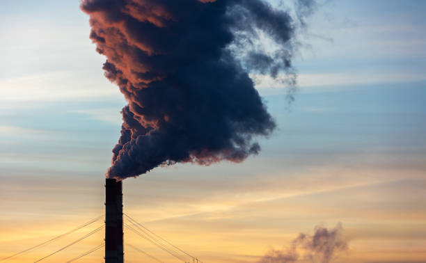 istock Thermal power engineering. CHP pipes with dark smoke against the background of the evening sky at sunset 1446315744