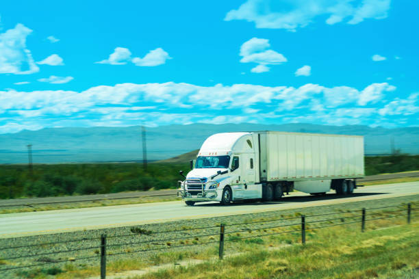 istock White semi-truck speeding on the highway 1446321004