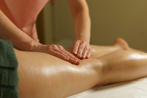 Foot massage. Massage therapist's hands and feet. Massage Studio