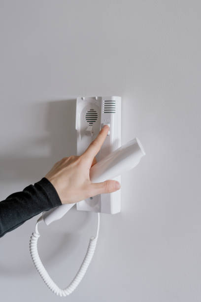 istock Woman open door in apartment using an intercom 1446328692