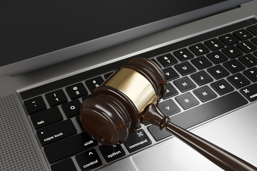 Judge gavel on a laptop. Illustration of the concept of new cybersecurity laws and regulations and its enforcement
