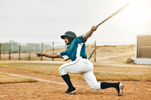 Baseball, sports and homerun with a man athlete or batter hitting and scoring during a game outdoor on a pitch. Sport, fitness and exercise with a male player on a field for training or a match