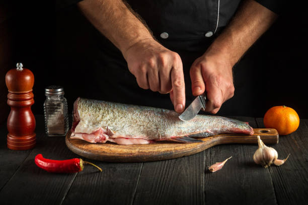 istock The chef cuts the fish before cooking. Working environment in the restaurant kitchen. Fish diet concept 1446329233