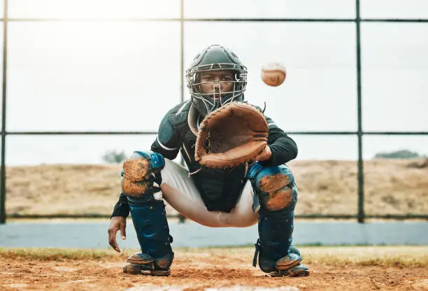 Photo of Baseball, catch and sports at the pitch for game, point or score with the ball on a field in the outdoors. Black man pitcher with mitt in sport training, exercise and fitness in competitive match