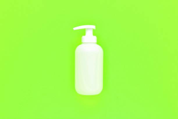 istock White unbranded plastic dispenser pump bottle on light neon green background with copy space 1446334663