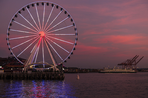 Seattle, USA - Sep 8th, 2022: A vivid sunset on the waterfront as a Ferry heads to Colman Dock.
