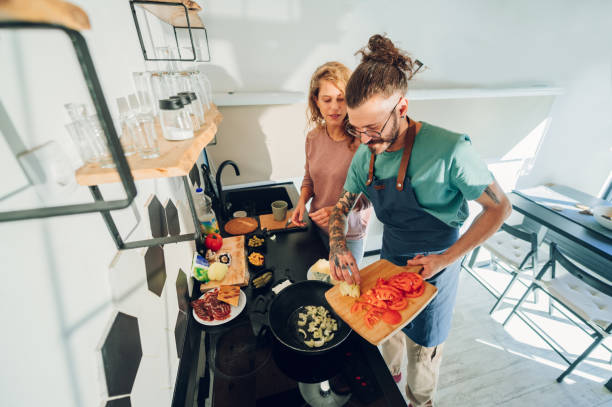 istock Young couple making breakfast together in the kitchen at home 1446339578