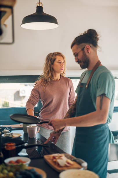 istock Young couple making breakfast together in the kitchen at home 1446339585