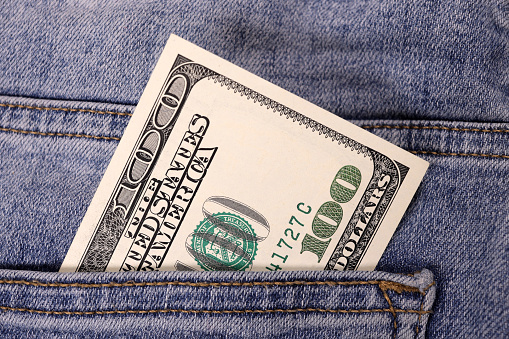 Banknot of hundred of US dollar in pocket of jeans. The concept of savings, investment, earnings. inheritance