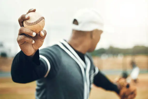 Baseball, athlete hand and ball sports while showing grip of pitcher outdoor in sport game. Exercise, game and softball with a professional player ready to throw or pitch during a match outside