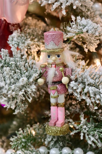 A small nutcracker Christmas tree ornament close-up