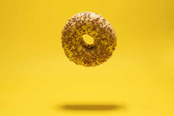 istock Levitating yellow donut on a yellow background. Creative sweet concept 1446348924