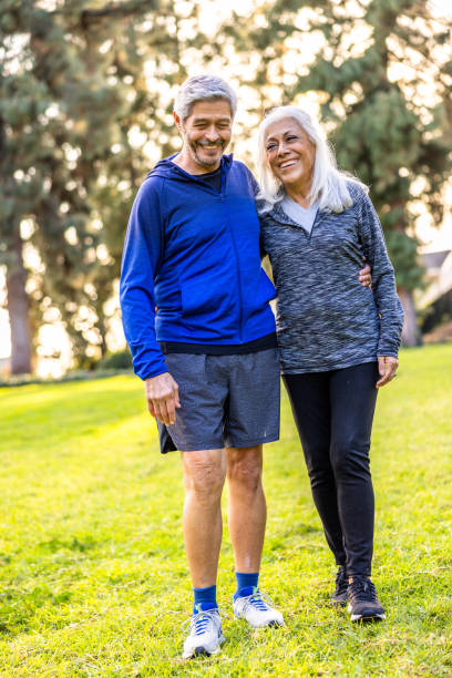 Senior couple walking together outside A senior couple walking outside and staying healthy body positive couple stock pictures, royalty-free photos & images