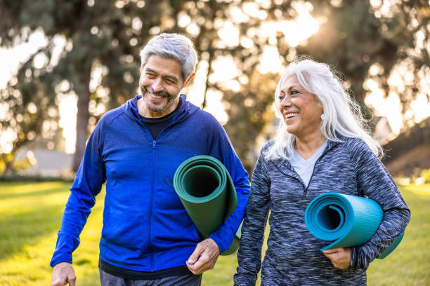 Senior couple with yoga mats A senior couple getting ready for a workout with yoga mats body positive couple stock pictures, royalty-free photos & images