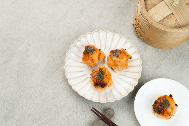 Cropped shot of a man holding a tray with an assortment of freshly served dim sum in a Chinese restaurant.