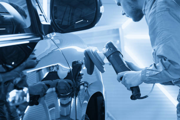 istock Man using polisher to polish black car body in the workshop 1446354626