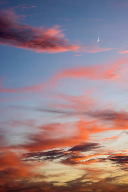istock New moon at sunset with red, orange and dark clouds 1446355898
