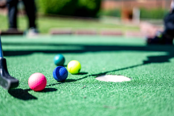 istock Mini golf game with several colored balls in the way of a putter lined up. 1446357339