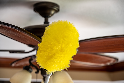 Concept of home cleaning tasks showing buildup of dust on a ceiling fan