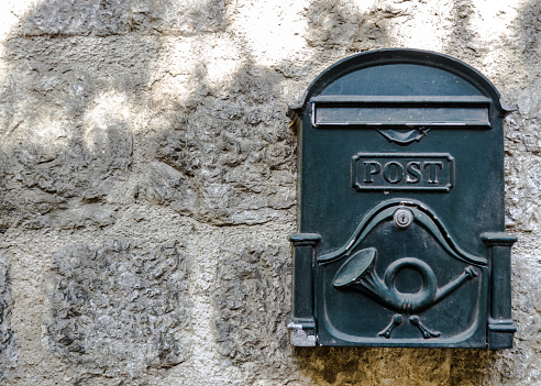 Close-up of an old mailbox on the outside wall of a house