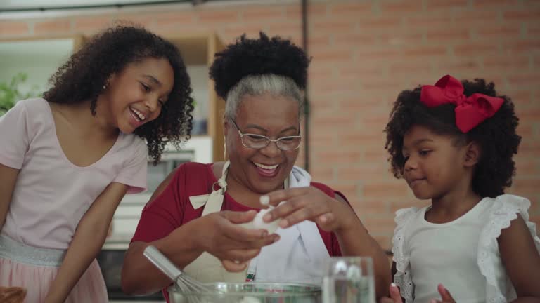 Grandma and granddaughters making Christmas cookies