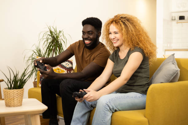 istock Happy couple playing video games at home 1446371179