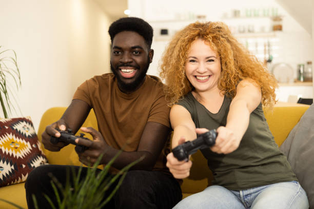 istock Happy couple playing video games at home 1446371188