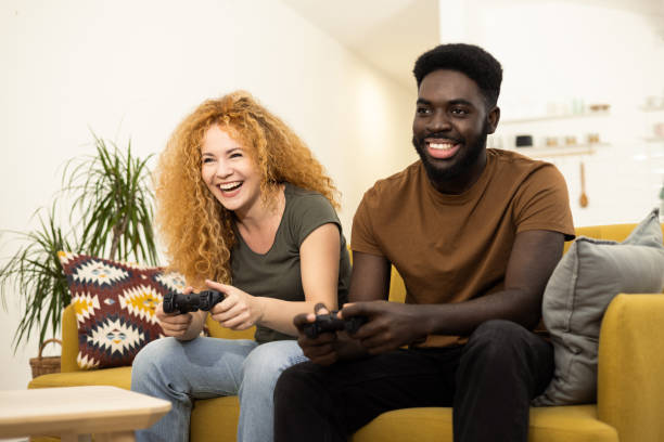 istock Happy couple playing video games at home 1446371228