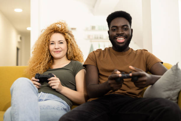 istock Happy couple playing video games at home 1446371233